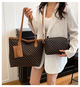 Sac cabas à monogramme vintage marron avec pochette porté sur un blazer blanc