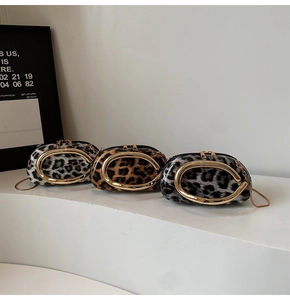 Close-up of leopard print party clutch bags with golden C-handle and chain strap