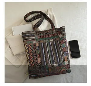 Ethnic style woven tote bag with colorful geometric patterns in a lifestyle setting