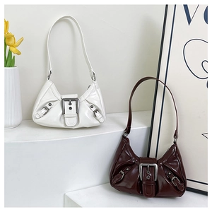 Detail of vintage pleated shoulder bags in white and dark brown with metallic buckles