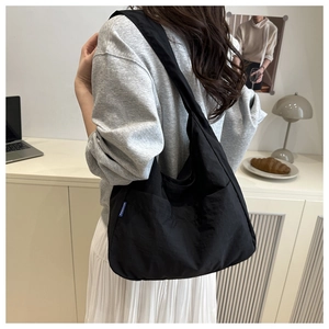 Detailed view of a black large-capacity tote bag worn on shoulder for daily commute
