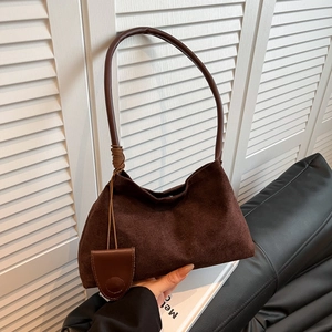 Minimalist dark brown suede underarm bag with slim shoulder strap and leather pendant