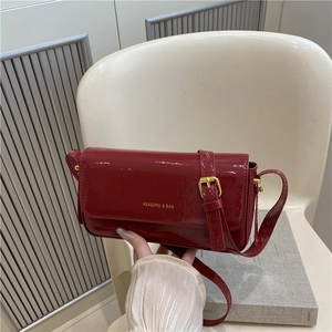 Bordeaux red glossy patent leather shoulder bag with gold logo and adjustable strap
