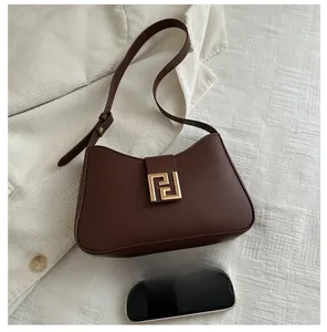 Detailansicht der braunen Leder-Umhängetasche mit goldener Schnalle und Handy-Größenvergleich