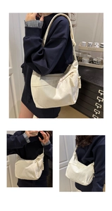 Detail view of the wide shoulder strap and corded zipper pull on this ivory corduroy bag