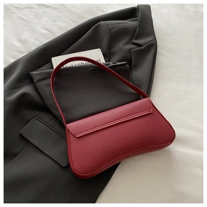 Detail of red pebbled leather shoulder bag with sleek flap closure and lock detail
