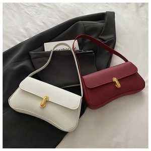 Detail of luxury lychee grain leather handbags with golden buckles on grey suit background