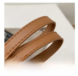 Détail macro de la bandoulière en cuir marron caramel avec double couture renforcée durable