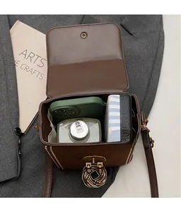 Detail of a brown suede box bag interior space and textured golden twist lock