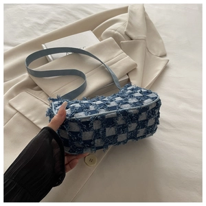Détail du sac sous l'aisselle en tweed à carreaux bleu et blanc avec bord effiloché