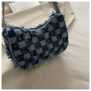 Détail du sac à bandoulière en denim à carreaux bleus avec bords effilochés et style Y2K