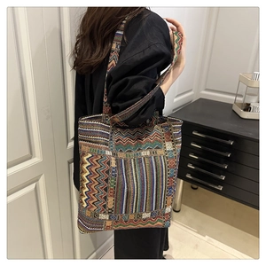 Detail of bohemian geometric woven tote bag featuring colorful chevron patterns