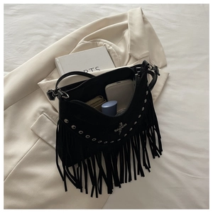 Detail of black bohemian tassel bag showing silver eyelets and cross pendant details