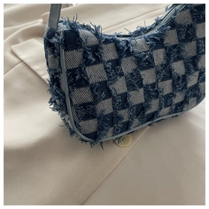 Détail du sac sous les bras en jean à carreaux bleu et blanc avec bords effilochés