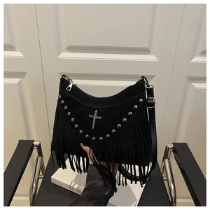 Detail of black suede shoulder bag with metallic cross, studs and long tassels