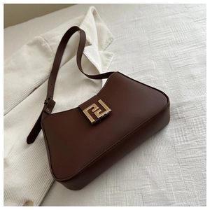 Detailansicht braune Ledertasche mit goldener Schnalle auf weichem weißem Stoffhintergrund