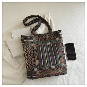 Detailed view of bohemian woven tote bag with geometric patterns on white fabric background