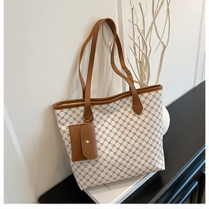 Détail d'un cabas à imprimé géométrique avec poignées en cuir et petite pochette