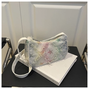 Detailed shot of white canvas bag with colorful star embroidery and fringe edges