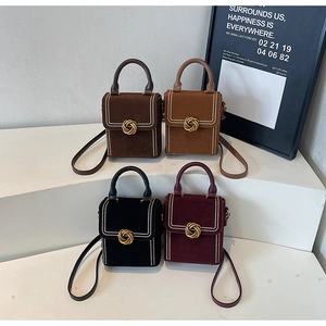 Gros plan de quatre sacs vintage mats avec fermoirs rotatifs dorés et rivets chics