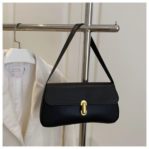 Detailed close-up of a black lychee texture underarm bag featuring a golden oval twist lock