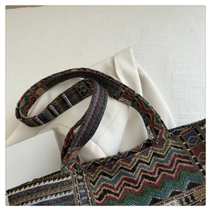 Close-up of bohemian woven tote bag with colorful wave patterns and wide strap detail