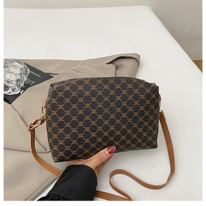 Détails d'un cabas vintage avec bandoulière en cuir réglable et boucles métalliques dorées