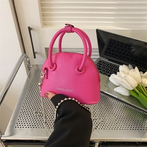 Mini shell-shaped crossbody bag in magenta lychee grain leather with silver chain strap