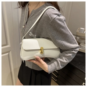 Detail of white lychee pattern leather bag with golden metal buckle and curved bottom