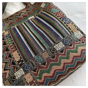 Close-up of the colorful ethnic woven pattern and detailed texture of the canvas tote bag