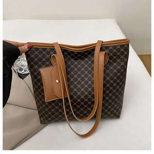 Détail macro du sac rétro montrant la toile à motif classique et la poignée en cuir brun