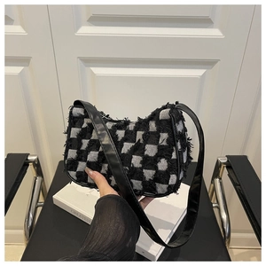 Détail du sac sous le bras en tweed damier avec bords effilochés et sangle en cuir