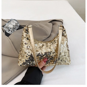 Close-up of golden sequins on a designer underarm bag with a metallic chain strap