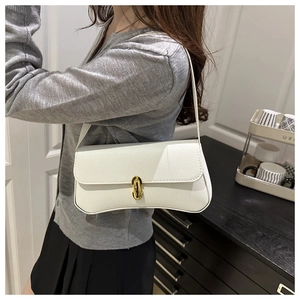 Close-up of white lychee texture leather handbag with elegant gold metal twist lock