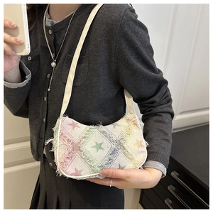Détail du motif d'étoiles en jacquard et bords effilochés sur un sac à bandoulière