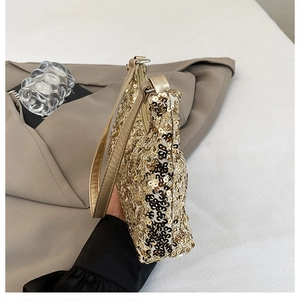 Close-up of golden sequins texture and zipper detail on the luxury underarm evening bag