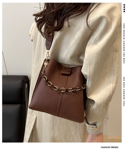 Close-up of brown litchi pattern bucket bag with decorative metal and acrylic chain
