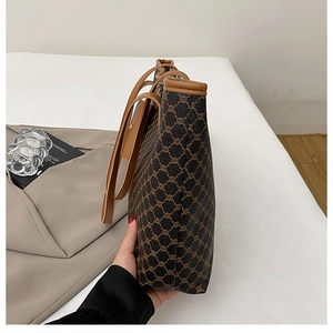 Détail du sac cabas vintage marron foncé avec monogramme et fines bretelles d'épaule