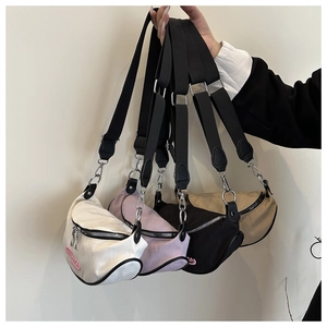 Detailed close-up of nylon dumpling bag colors with adjustable strap and pink embroidery