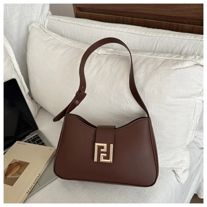 Detail der kaffeebraunen Ledertasche mit bogenförmiger Öffnung und goldener Schnalle