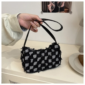 Detail of checkered canvas underarm bag featuring fringe edges and black PU strap handle