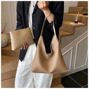 Fashionable woven hobo bag and matching pouch set worn by model in urban office style