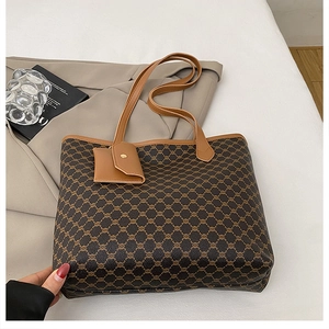Détail du sac cabas vintage marron à monogramme avec pochette assortie sur fond minimaliste