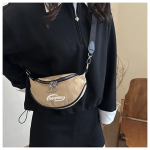 Close-up of khaki crescent bag with FANYISSA embroidery and silver ring zipper detail