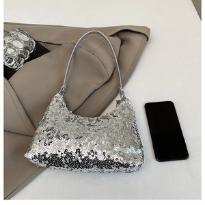Detail of silver sequin crescent hobo bag showing reflective texture and leather strap