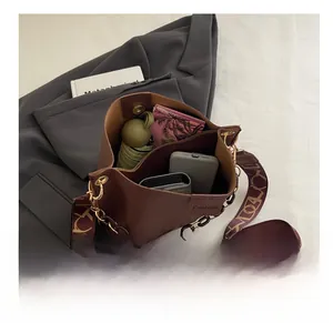 Interior capacity display of dark brown bucket bag with wide strap and daily essentials