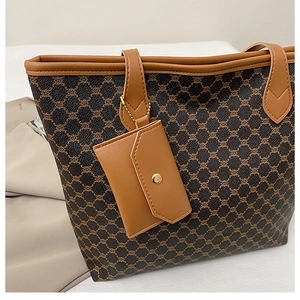 Détail du sac cabas monogramme rétro avec finitions cuir et mini pochette assortie
