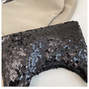 Close-up of high-density black sequins on a luxury evening shoulder bag with shimmer