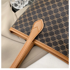Gros plan d'un sac cabas en toile vintage avec motif classique et détails en cuir