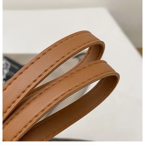 Gros plan sur la bandoulière en cuir marron avec coutures renforcées d'un grand cabas